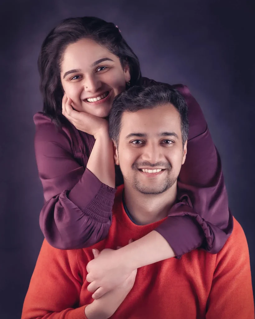 Smiling couple portrait with woman embracing man from behind in a Christchurch studio
