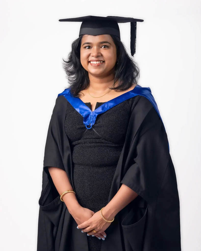 Graduation portrait of a smiling woman in cap and gown in Christchurch studio