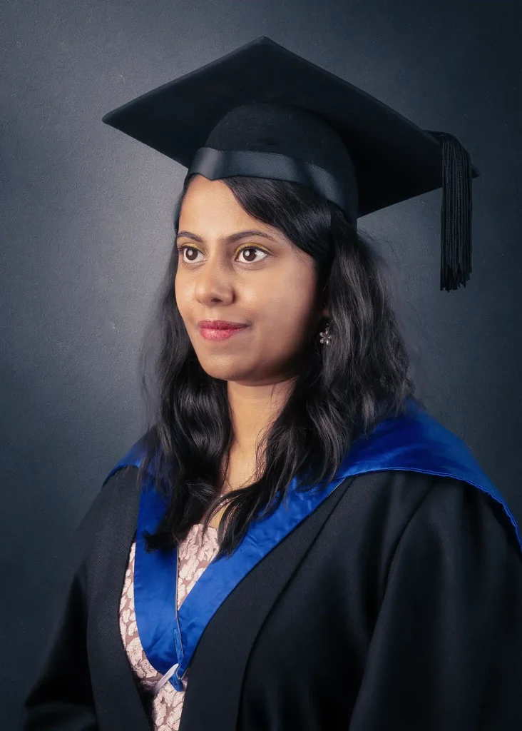 Female graduate in cap and gown posing for professional graduation portrait