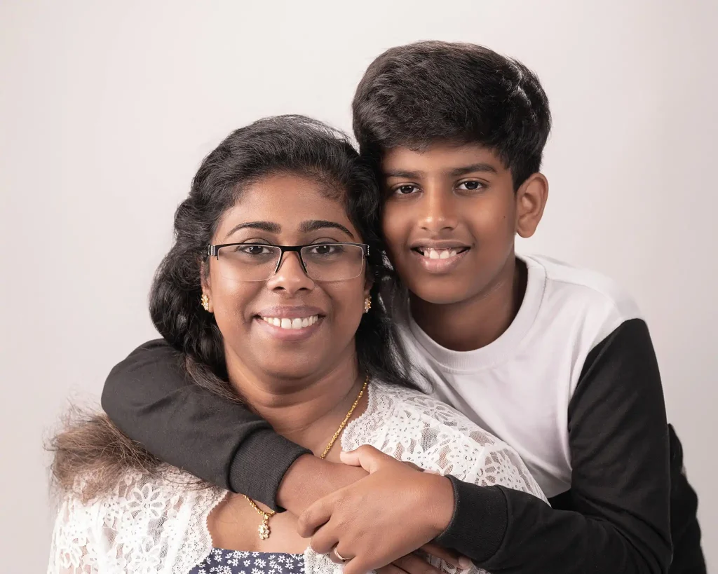 Studio portrait of smiling mother with her son hugging from behind in Christchurch