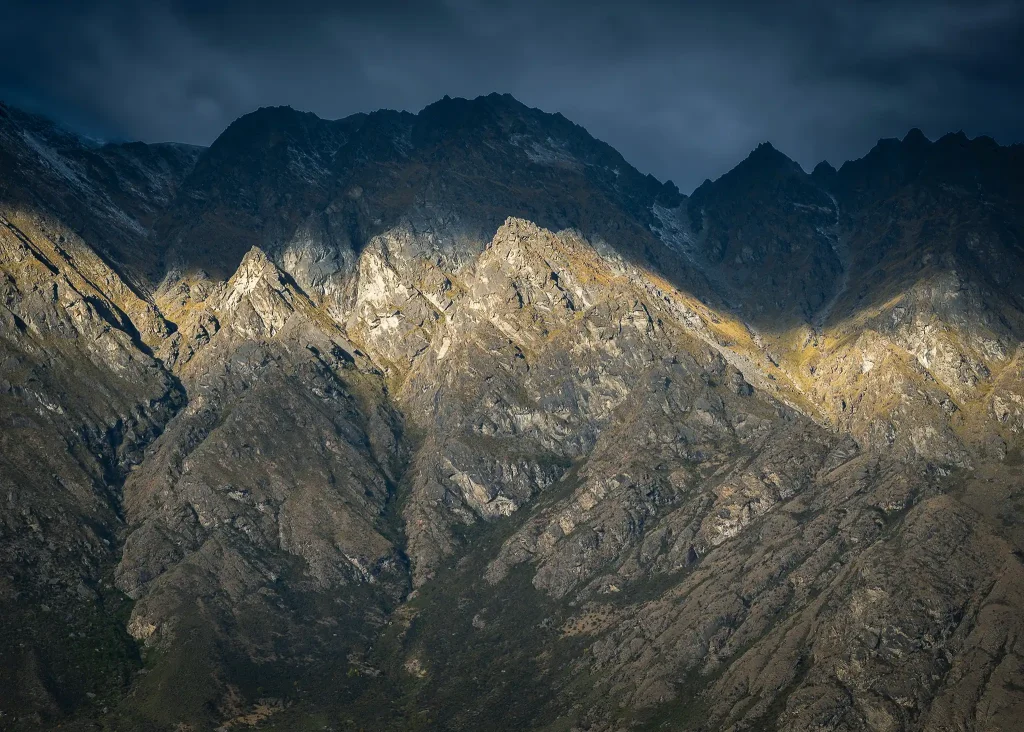 Dramatic sunlight and shadow over the Remarkables mountains in Queenstown, New Zealand